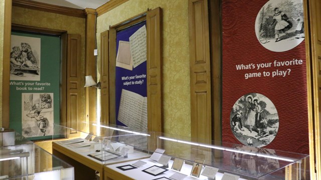 artifacts in exhibit cases, including children's artwork