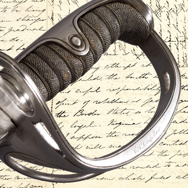 Detail of saber handle engraved C.A. Longfellow over background of manuscript letter