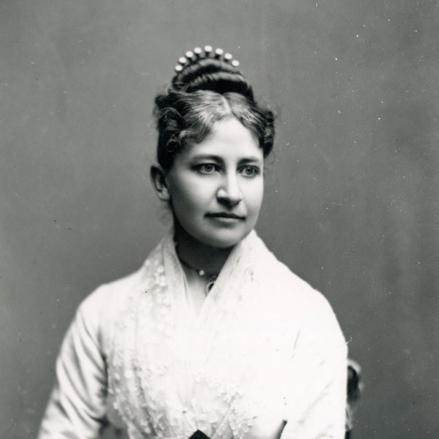 Seated portrait of a white woman with dark hair.