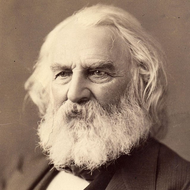 Bust-length portrait of Henry Longfellow with white hair and beard