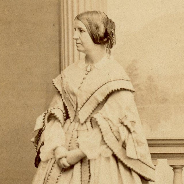 Full-length photograph of woman standing in floor-length dress