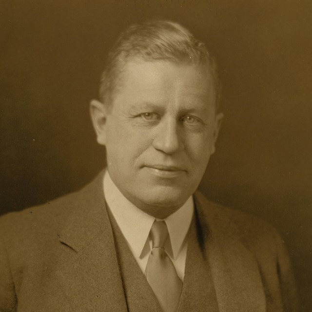 Studio portrait of man in three-piece suit and tie.
