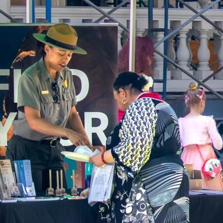 Park ranger talking to a visitor at an outdoor tent