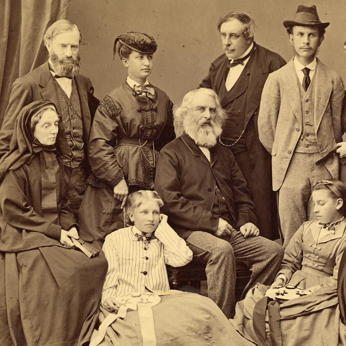 Group studio portrait of men, women, and girls around Henry Longfellow