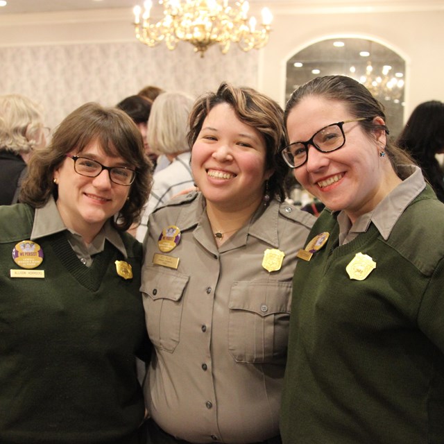 Three rangers stand arm in arm at the Lowell Women's Week celebration