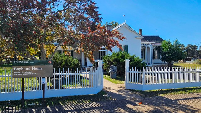 Small, white house with white picket fence