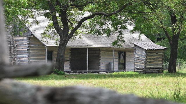 Historic wooden cabin surrounded by trees