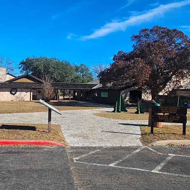 Stone building in background, information signs in foreground.