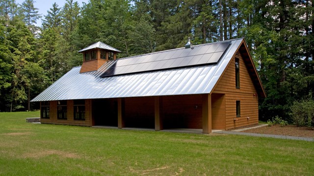 Wood building with pitched metal roof with solar panels. 