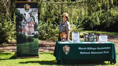 Ranger stands in front of table with brochures