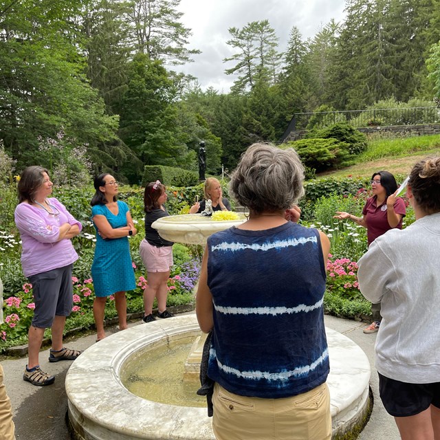 teachers talk in formal garden around fountain