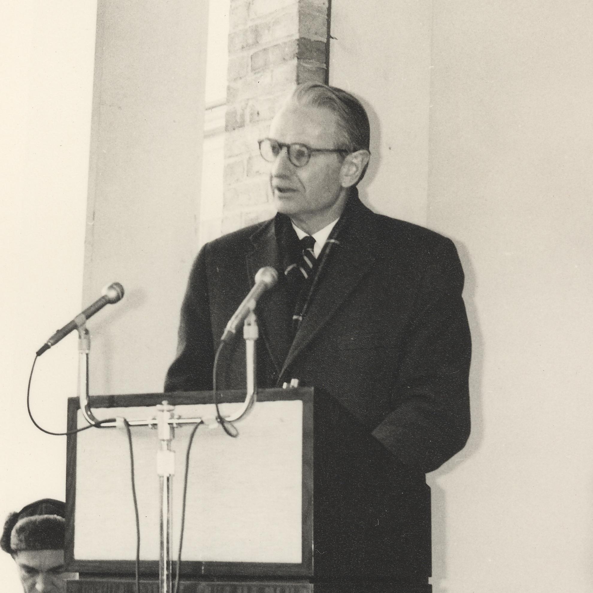 Laurance Rockefeller stands at a podium and delivers a speech at the opening of the Woodstock Inn
