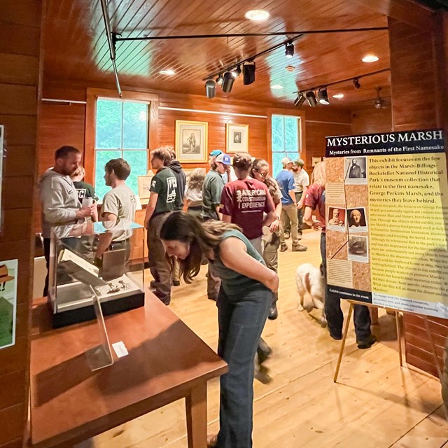 group of people in a small room with a museum exhibit, title reads 