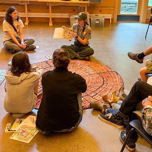 park ranger reads a story to a group of families