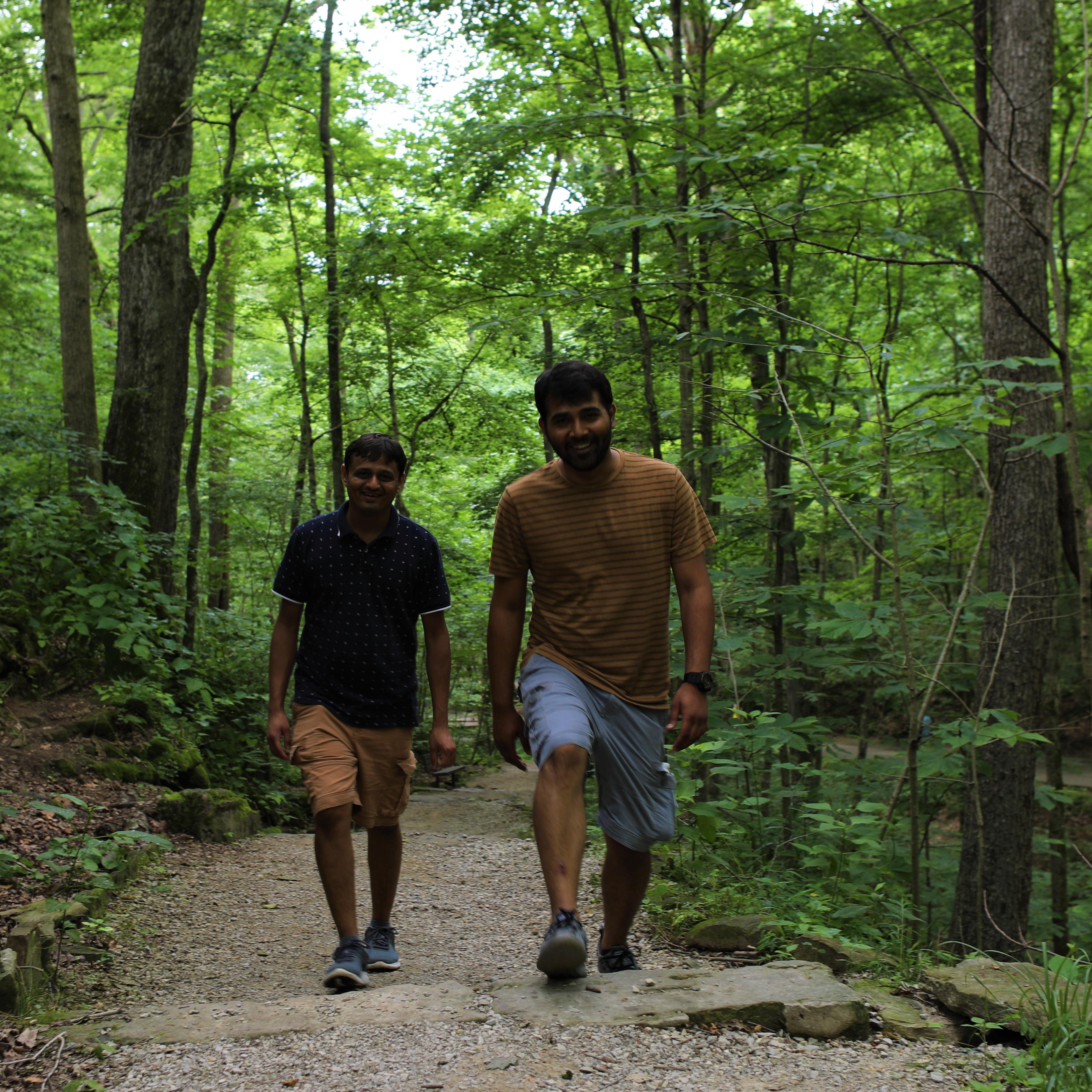 Two young men hike on a park trail