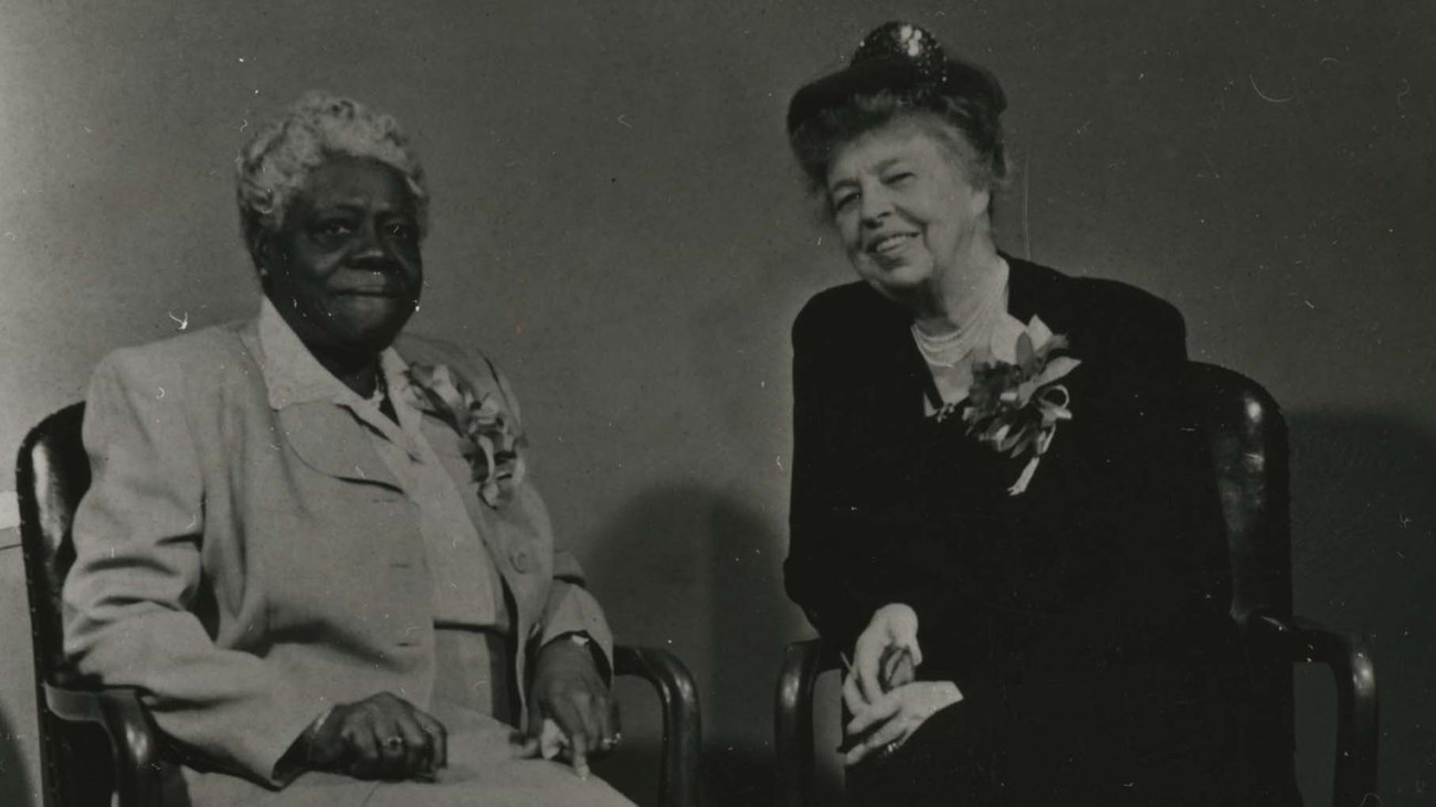 Black and white photo of Mary McLeod Bethune and Eleanor Roosevelt sitting next to one another