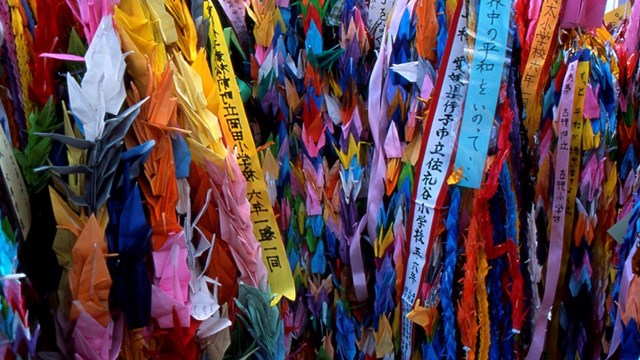 A collection of bright colored paper hanging in a bunch.