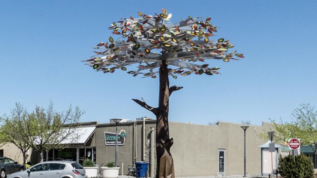 A sculpture of a tree in a roundabout.