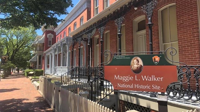 A brick row of townhouses with a sign that says "Maggie L. Walker National Historic Site"
