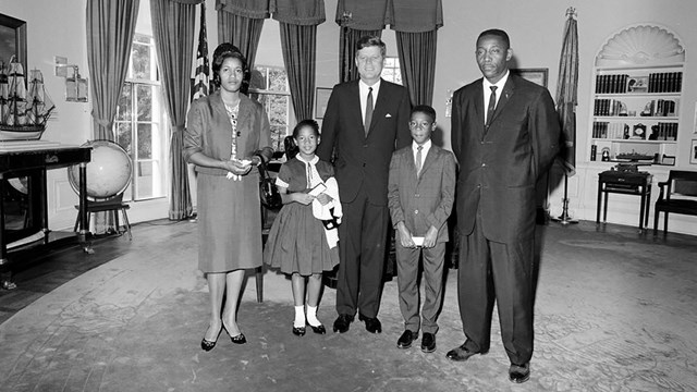Myrlie, Darrell, Reena, and Charles Evers stand in the Oval Office with President Kennedy