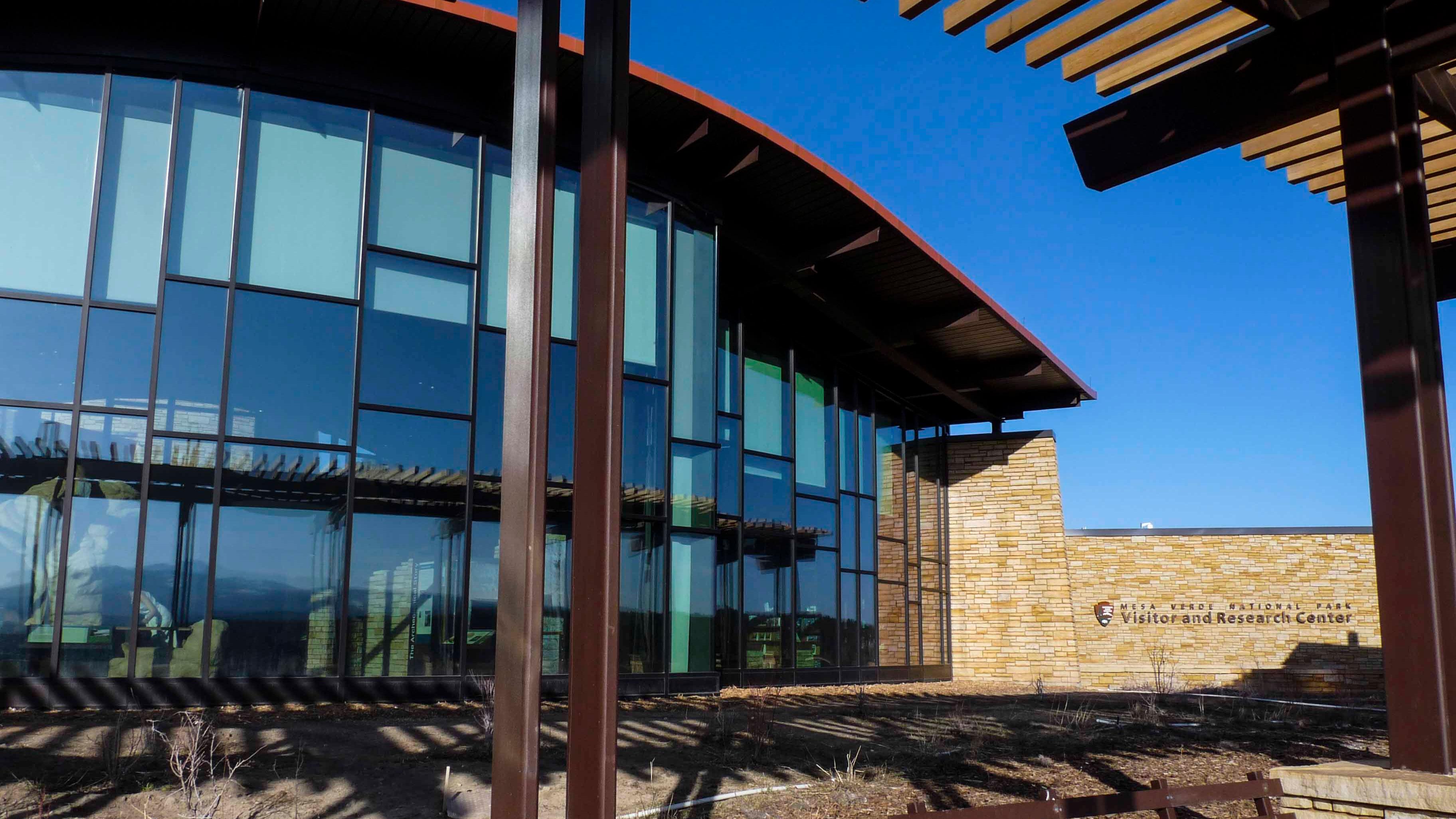 a bank of curved windows with tint form one wall of the Visitor and Research Center
