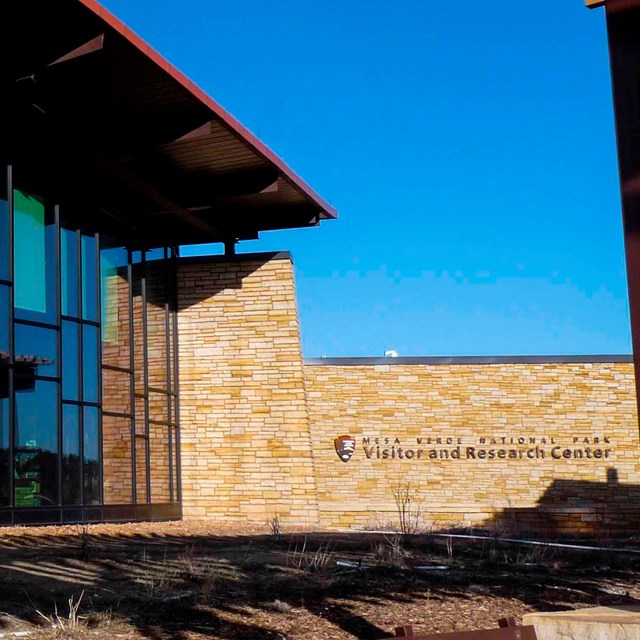 a bank of curved windows with tint form one wall of the Visitor and Research Center