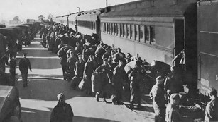 Hundreds of soldiers on platform boarding trains.