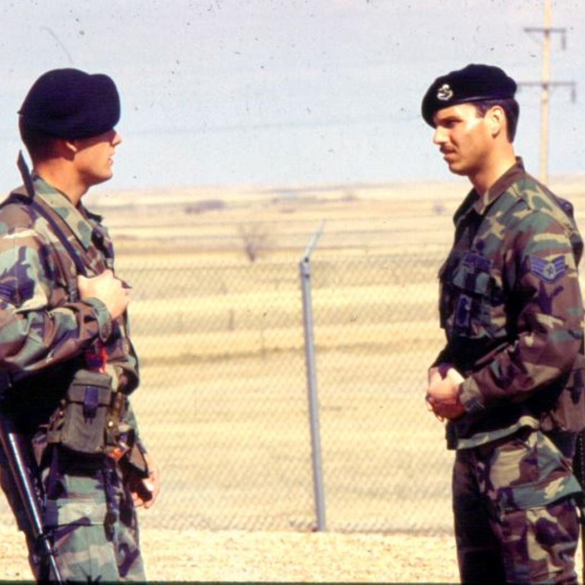 Two missile security policemen standing beside a fence
