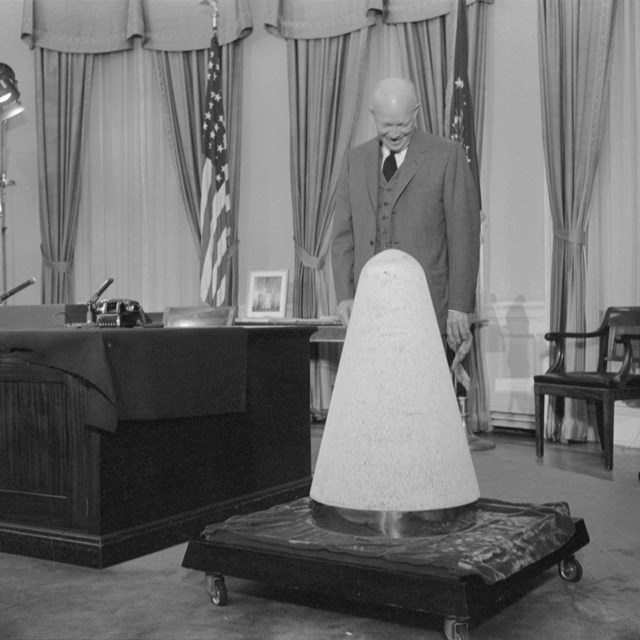 President Eisenhower looks at a missile nosecone in the Oval Office