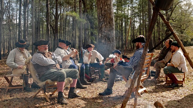 Living historians gathered around a fire.
