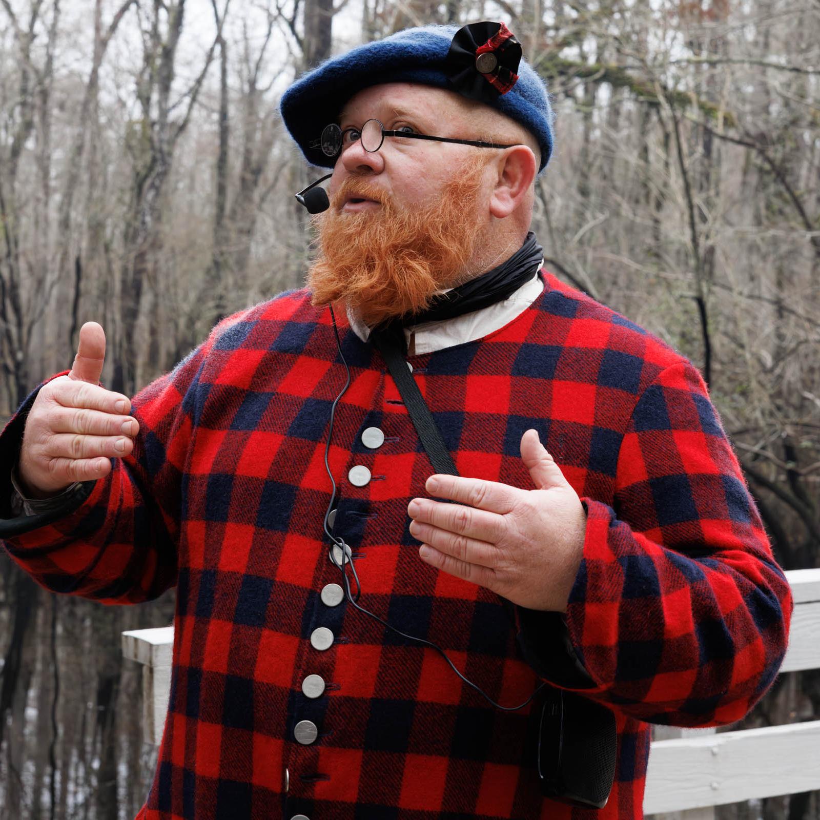 Man in Highland Plaid Clothing on a Wooden Bridge