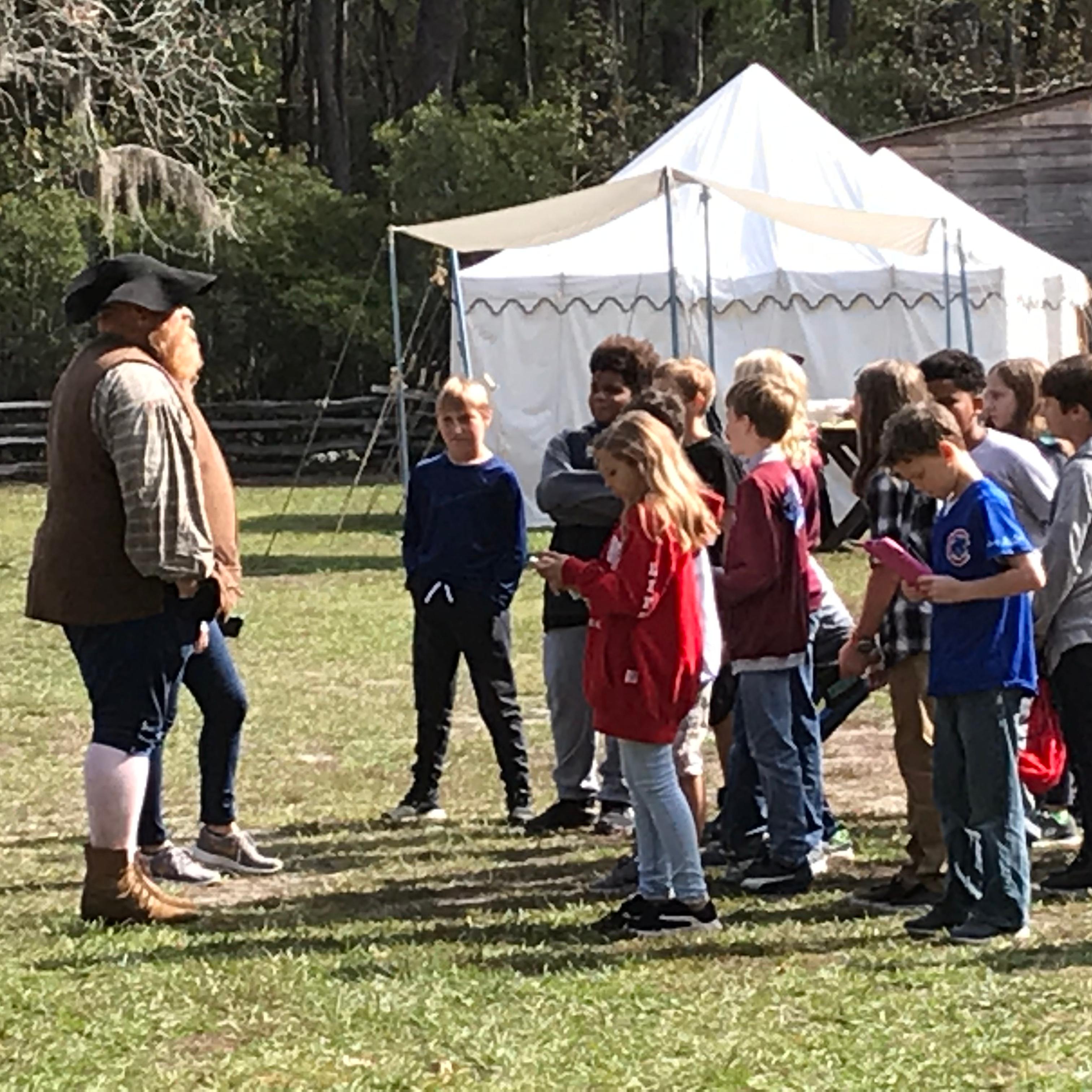 Ranger in period dress talking with students.