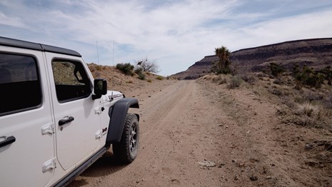 a white Jeep on a dirt road