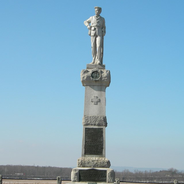 A statue of a Union Civil War soldier on top of a tall square pedestal.
