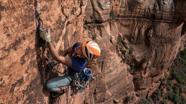 Female aid climbing big wall in Zion National Park
