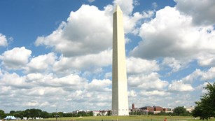 Washington Monument with blue sky and puffy clouds