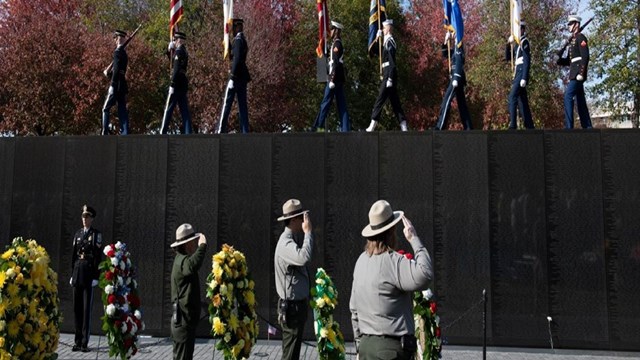 Park Ranger salute as a color guard marches by.