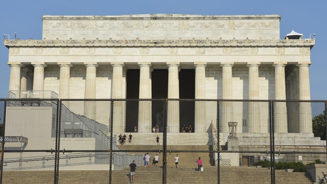 White sign with black lettering that says "Road Closed"