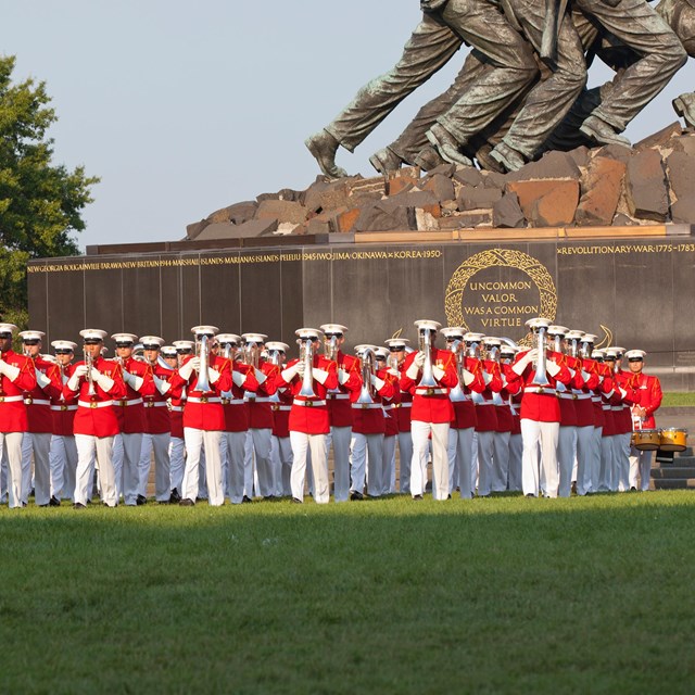 US Marine Drum and Bugle Corps in formation at the base of a statue