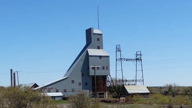 Tall, metal-clad building standing next to a metal frame.