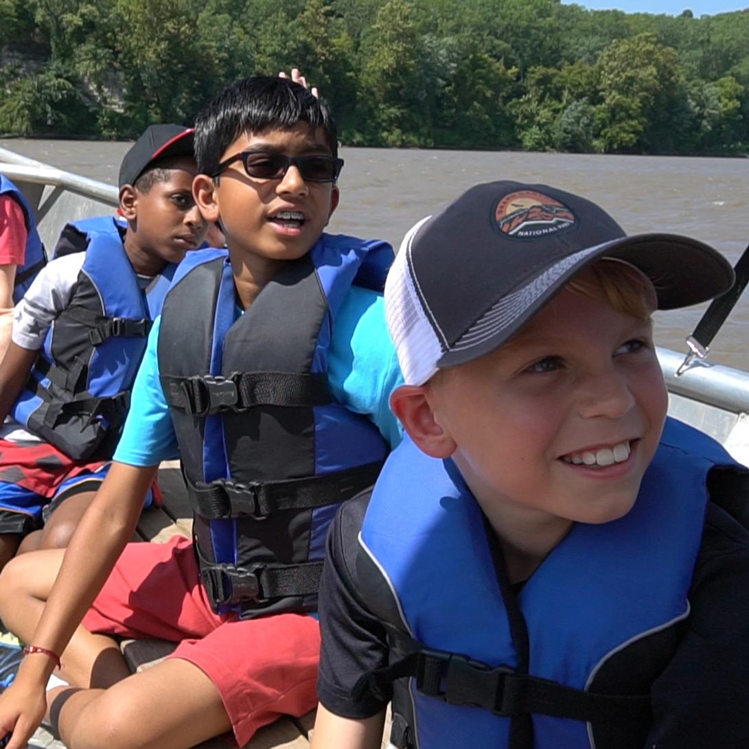 Students sitting on a boat on a river