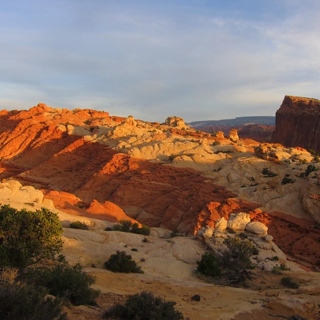 Evening light over sedimentary layers of red and light rock