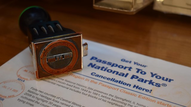 A rubber stamp labelled "New Philadelphia National Historic Site" lies on a countertop.