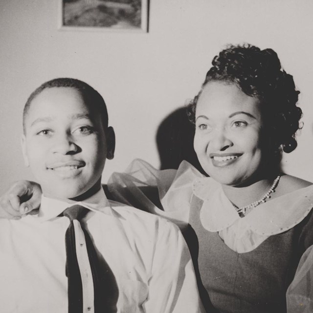 o	Alt Text: An African American woman and teenage boy sit side by side. He looks at you, smiling.
