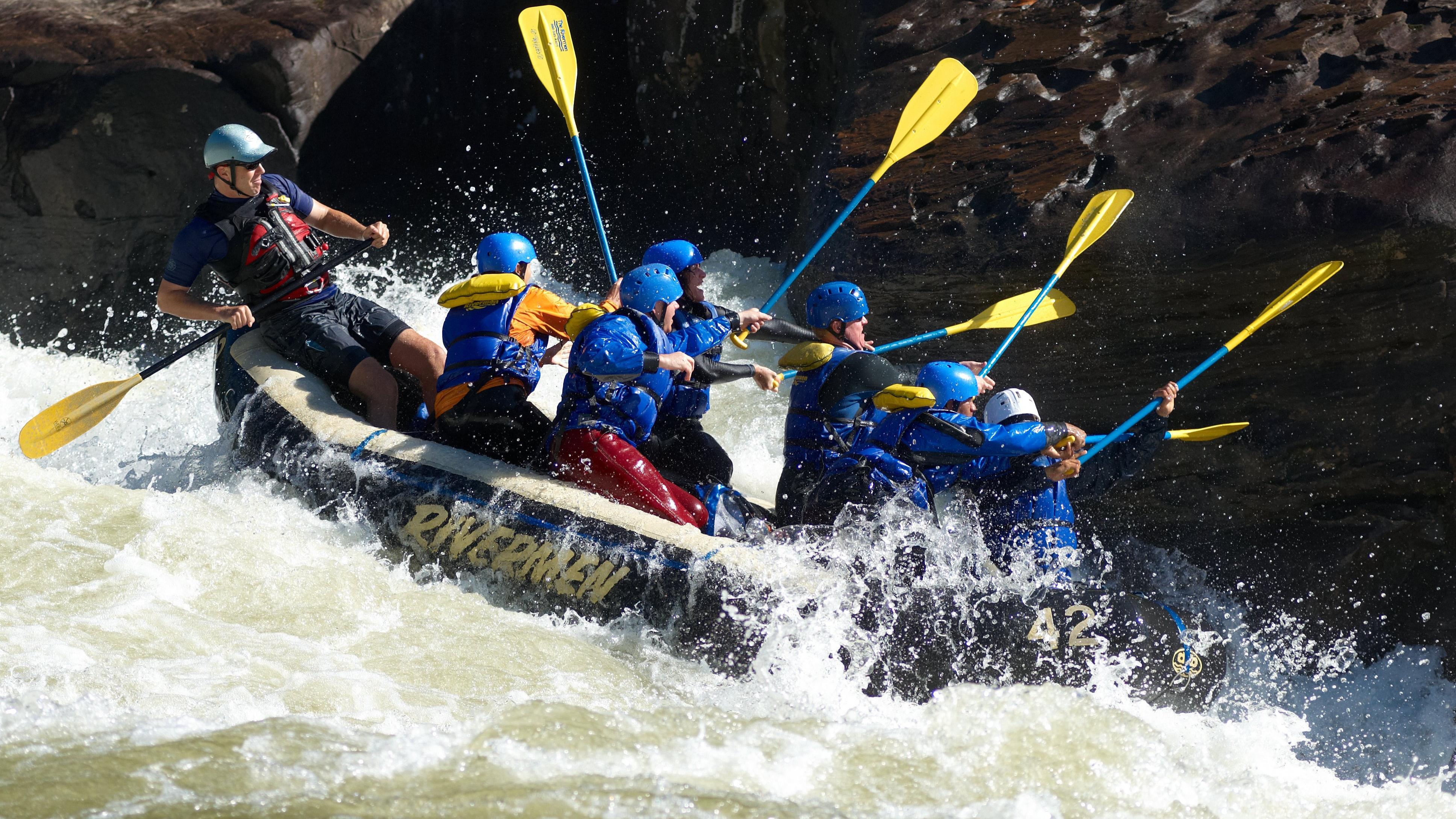 rafters paddle through whitewater