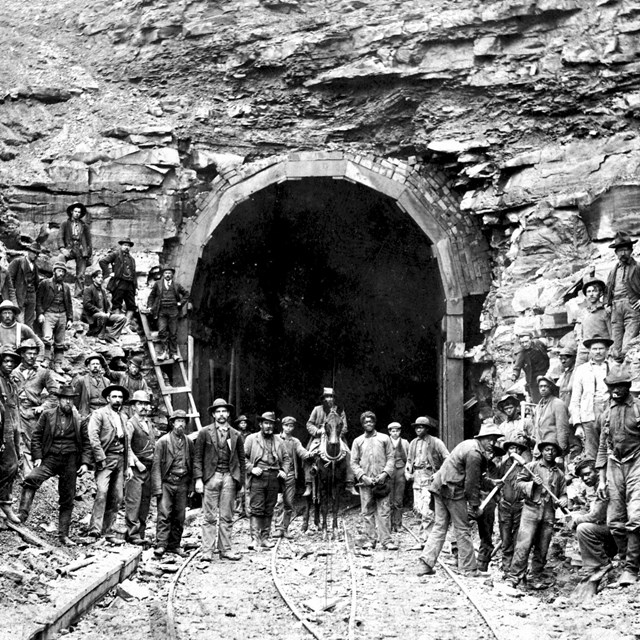 black and white photo of workers digging tunnel