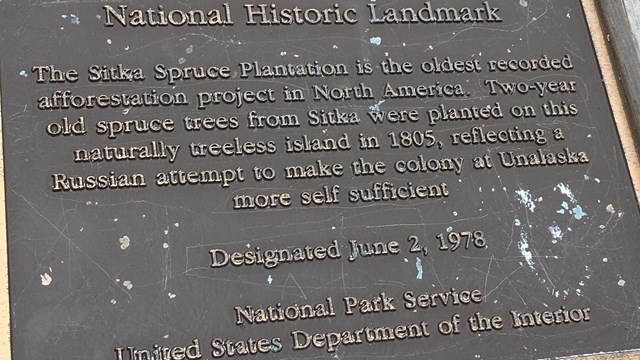 A bronze national historic landmark plaque for the Sitka Spruce Plantation, Unalaska