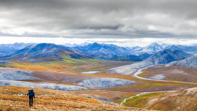 Hiker crosses arctic landscape near Nakolik Mountain