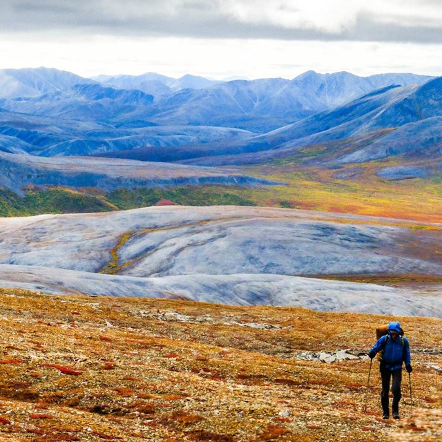 woman hiking with mountains behind her
