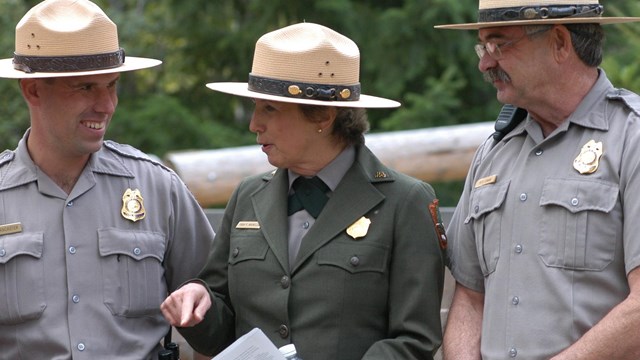 three park rangers standing in a row 